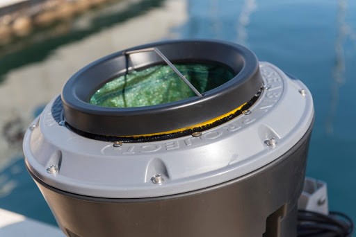 Mounted telescope viewing lens showing marina waters and boats below.
