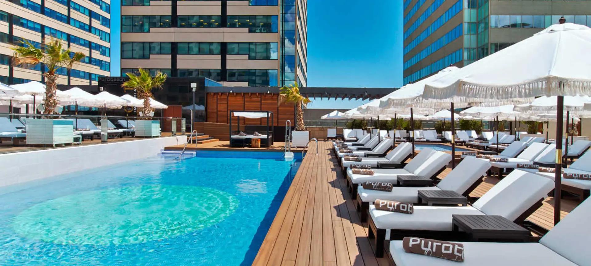 Poolside loungers at Purobeach Club in Barcelona, the perfect spot to relax and enjoy the summer.