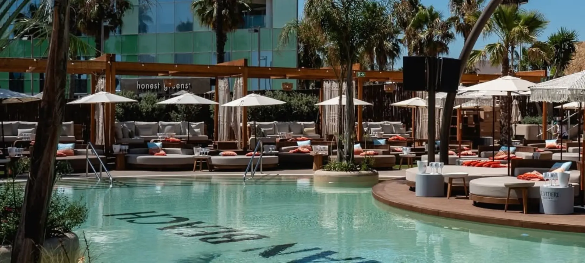 Poolside view at Bastian Beach Club in Barcelona, with loungers and parasols perfect for relaxing in the chill-out area during summer.